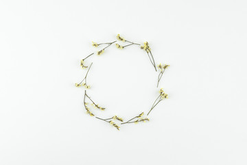 Round wreath made from yellow limonium caspia flowers on white background with copy space