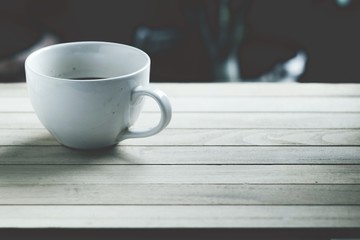 White coffee cup on wooden floor, Vintage style