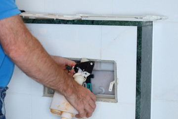 Installateur montiert Spülkasten