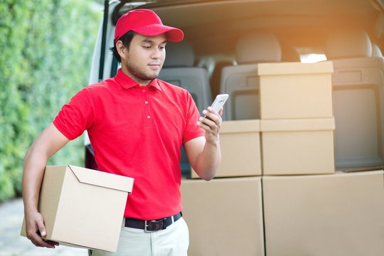 parcel delivery man stand use phone and contact the customer. counting Check stock Prepare to send the package to the customer. Validate every time in transportation.