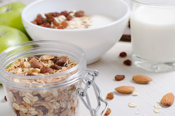 Healthy Breakfast. Oatmeal with raisins and yogurt. Milk in a glass. Fruit, nuts on a white table