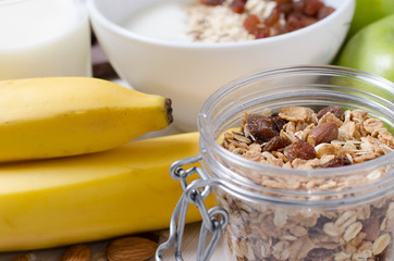 Healthy Breakfast. Oatmeal with raisins and yogurt. Milk in a glass. Fruit, nuts on a white table