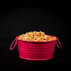 yellow fresh corn seed in bucket on black