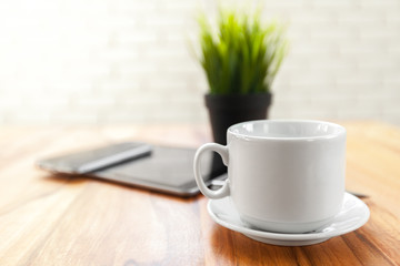 Digital tablet and black coffee on wooden table