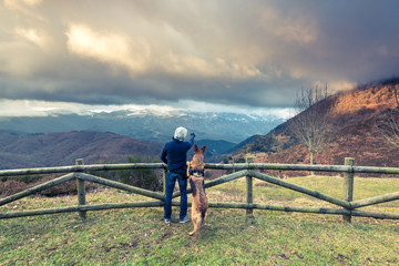 Fototapeta na wymiar Man and dog admiring view in mountains