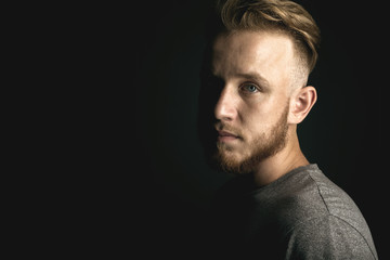 portrait of young man above black background