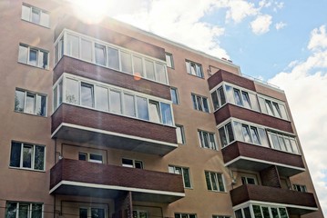 Obraz premium часть коричневого дома с балконами и окнами на фоне неба в солнечном свете