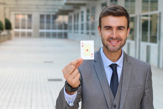 Businessman showing the ace of hearts - Powered by Adobe
