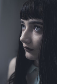 Portrait of a a beautiful young girl with dark hair and blunt bangs