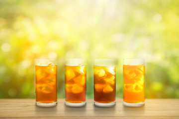 Coffee clod brew process (Method). Full glass of cold black coffee on teak wooden table. Isolated on green yellow nature light bokeh background with clipping path.