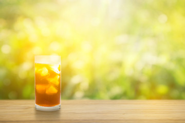 Coffee clod brew process (Method). Full glass of cold black coffee on teak wooden table. Isolated on green yellow nature light bokeh background with clipping path.