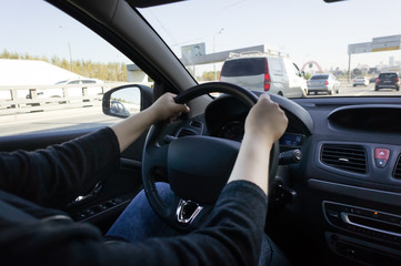 woman driving car, hands hold steering wheel