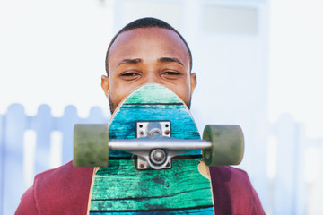 Man holding his longboard and hiding the face.