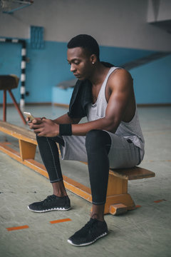 Young Man Checking His Phone During Workout