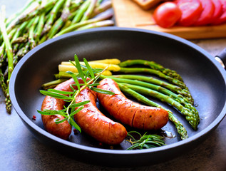 Sausage with asparagus in a pan