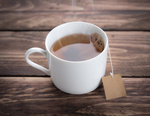 Cup of tea and teabag on wooden table