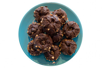 Chocolate muffins with nuts on the plate top view isolated on white