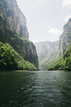 Scenic valley view of canyon and lake surrounded by vegetation in Chiapas, Mexico.