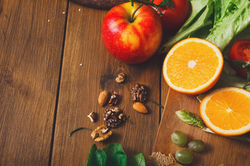 Wooden table served with cut fruits and vegetables