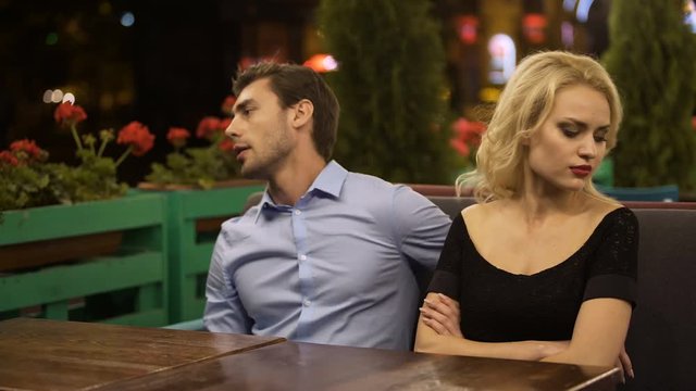Upset young woman getting angry at her boyfriend on date, relationship problem