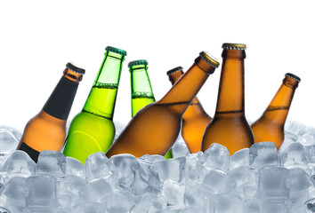 Cold bottle of beer with drops in ice cubes isolated on a white