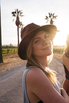 young woman wearing hat at sunset on california road