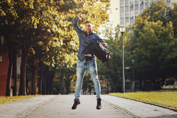 Young happy businessman jumping in air
