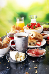 Breakfast served with coffee, orange juice, croissants and strawberry, jam and tea.