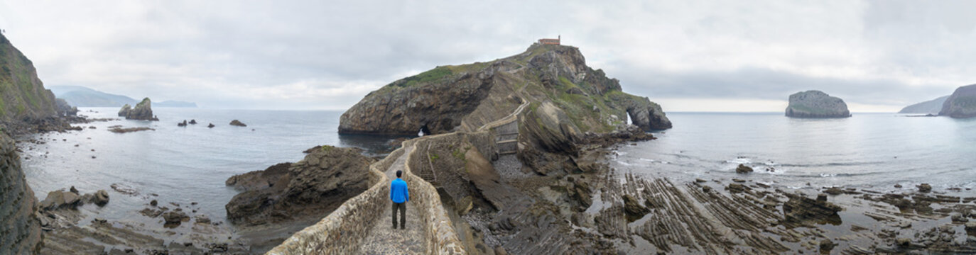 Man walking towards an amazing island in Gaztelugatxe