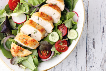 Chicken salad with leaf vegetables and cherry tomatoes.