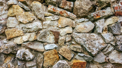 Stone old wall from huge blocks. Background of stones. The concept reliability. The space between stones is filled with cement.
