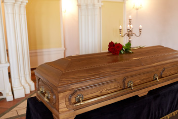 red rose flowers on wooden coffin in church