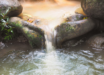 Beautiful streams of water flowing from the beautiful waterfall in the forest, Close up