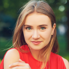 Naklejka premium Face of happy beautiful successful business woman posing on the street in summer in red dress. Friendly smiling blonde girl looking at camera with cheerful confident expression
