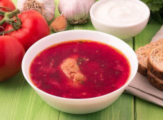 borscht - a soup based on beet, it has a characteristic red color. A traditional dish of Eastern Slavs, South Russian and Ukrainian cuisine. Dish, garlic, greens, bread, tomatoes and sour cream