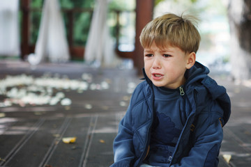 Little boy crying while sitting in the Park