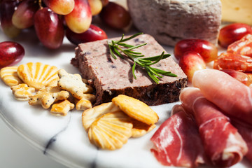 Food tray with charcuterie assortment, cheese  and grapes