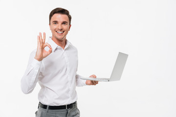 Portrait of a smiling handsome man holding laptop