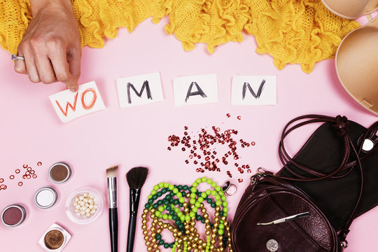 Man in women's jewelry puts the inscription on pink background