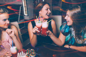 Happy friends party. Joyful leisure time. Smiling females with cocktails and grossip, New Year...