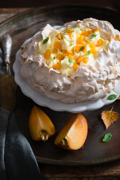 Pavlova with custard and persimmon on a cake stand