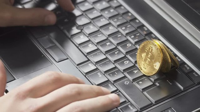 Man typing on keyboard with bitcoins