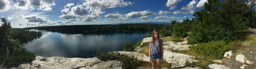 Naklejka na ściany i meble Teenage girl standing by lake. 