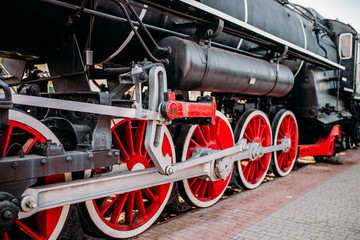 Fototapeta na wymiar Old steam train, red wheels closeup