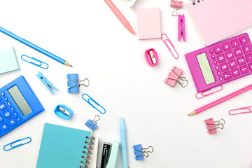 Stationary concept, Flat Lay top view Photo of Scissors, pencils, paper clips,calculator,sticky note,stapler and notepad in pink and blue tone on white background with copy space