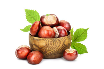 Chestnuts with leaves in wooden basket on white background. An isolated object.