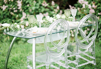 decorated wedding table for two with beautiful flower composition of flowers, glasses for wine, outdoor, fine art.