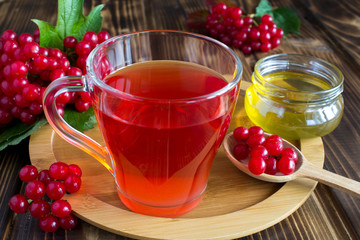 Tea with viburnum and honey on the round wooden cutting board