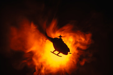 Helicopter over fire sunset horizon. War concept. Military scene of flying helicopter fire backgroung effect. Decoration © zef art