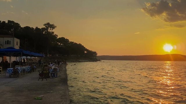 Pylos in Greece against a beautiful sunset with people enjoying their summer vacations.
